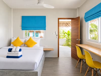Beach bungalow bedroom with a double bed, desk and open entrance