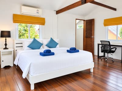 Air-conditioned beach house bedroom with yellow blinds and wooden floors