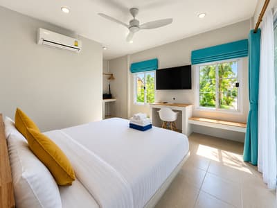 Beach studio bed and work surface beside an open wooden door