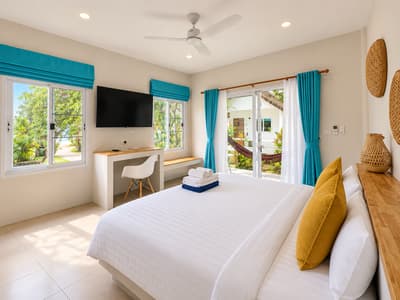 Window and white desk beside the bed in a beach studio